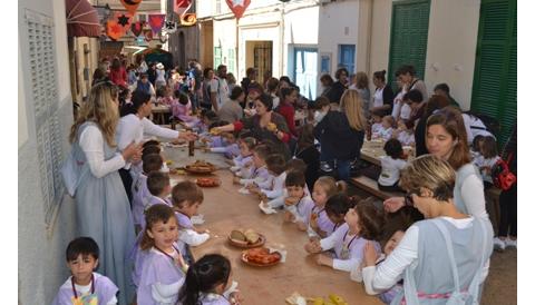 Els escolars comencen la festa amb un pa amb oli medieval